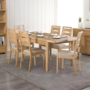 Wooden dining table set with chairs in a room with a bookshelf and decorative items.