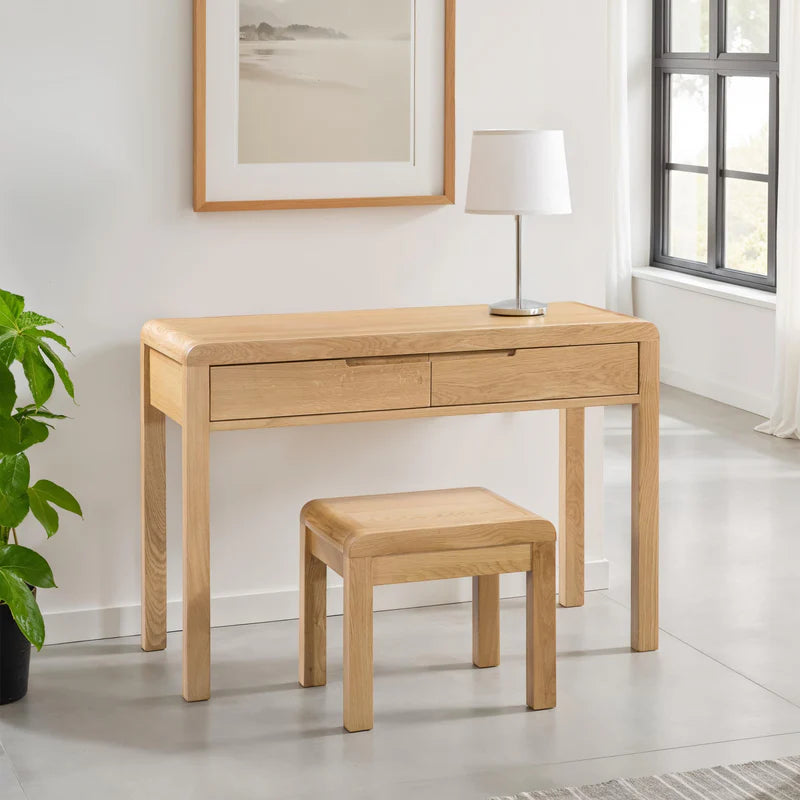 Wooden desk with two drawers and a matching stool on a white background