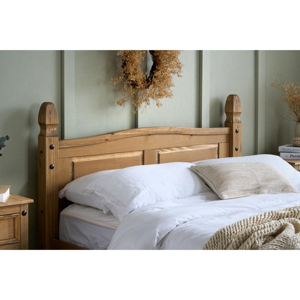 Wooden bed with white bedding in a bedroom setting