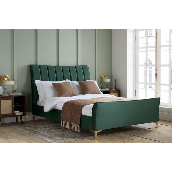 Green upholstered bed in a bedroom with neutral decor