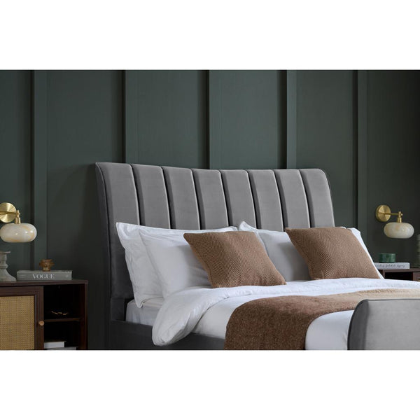 Bedroom with a gray upholstered headboard, white bedding, and brown pillows.