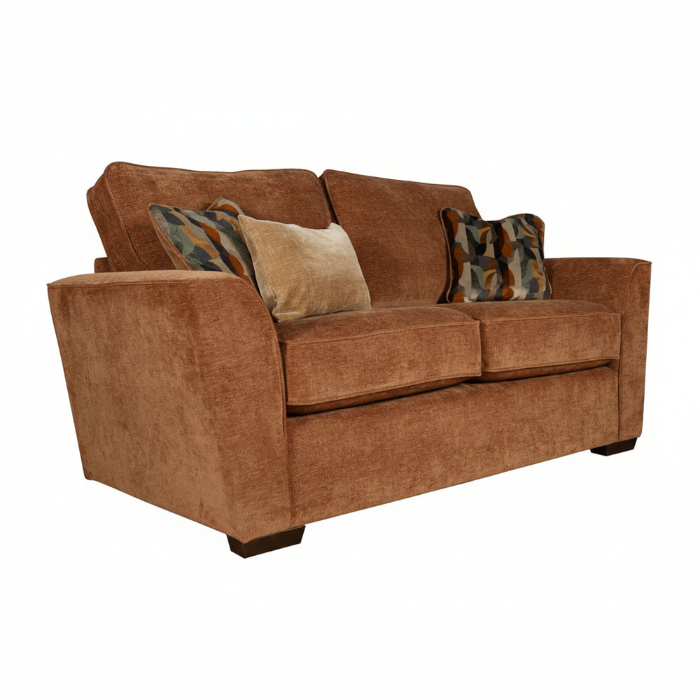 Brown sofa with patterned and solid cushions on a white background