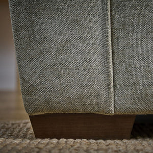 Close-up of a textured fabric surface with wooden base on a blurred background