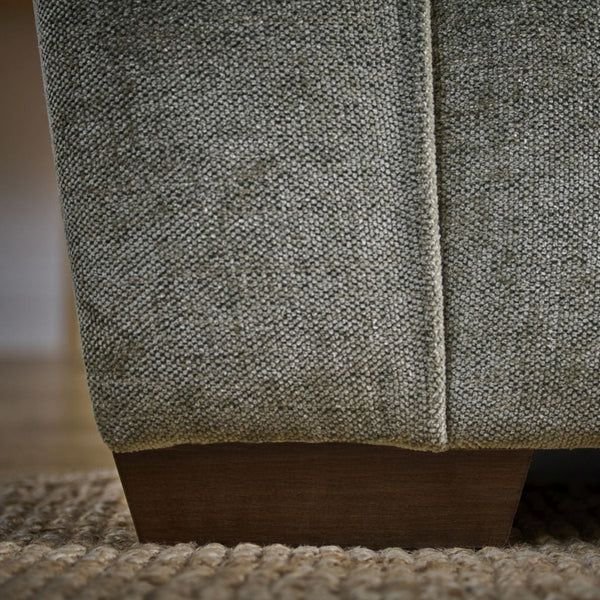Close-up of a textured fabric surface with wooden base on a blurred background