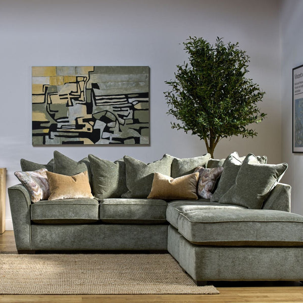 Gray sectional sofa in a living room with abstract art and plants.
