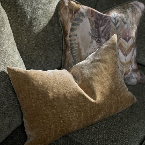 Two patterned pillows on a gray sofa