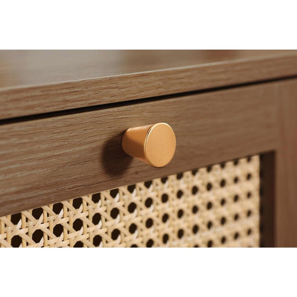 Close-up of a wooden drawer with a gold knob and wicker patterned side.