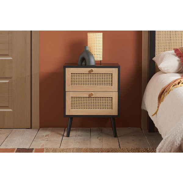 Wooden nightstand with two drawers against a warm-colored wall.