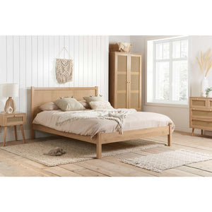 Wooden bedroom furniture set with bed, wardrobe, and side table in a bright room.