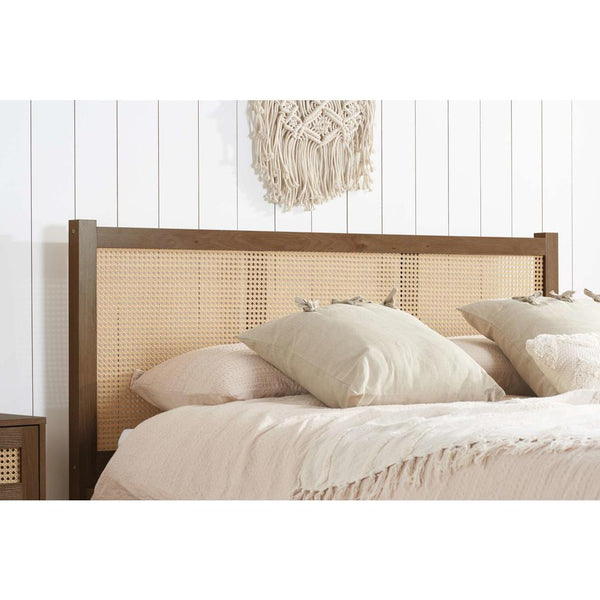 Bed with wooden headboard and white bedding against a white wall.