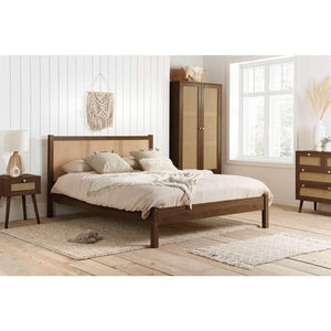 Wooden bed in a bedroom setting with a wardrobe and side table.