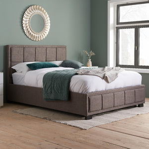 Bedroom with a brown upholstered bed and decorative elements.