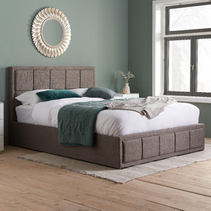 Bedroom with a brown upholstered bed, white bedding, and decorative elements.