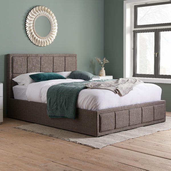 Bedroom with a brown upholstered bed, white bedding, and decorative elements.