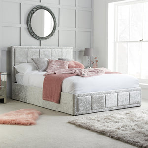 Neatly made bed with decorative pillows and blankets in a bedroom setting.