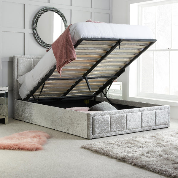 Gray upholstered bed with open storage compartment in a bedroom setting.