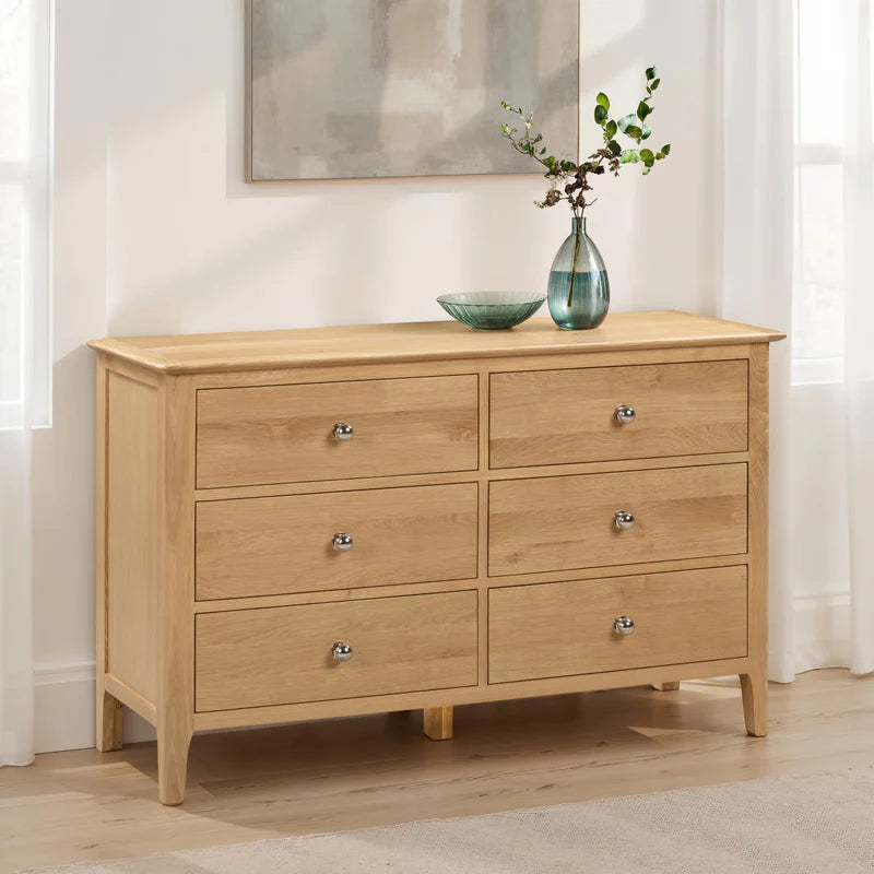 Wooden dresser with six drawers on a white background