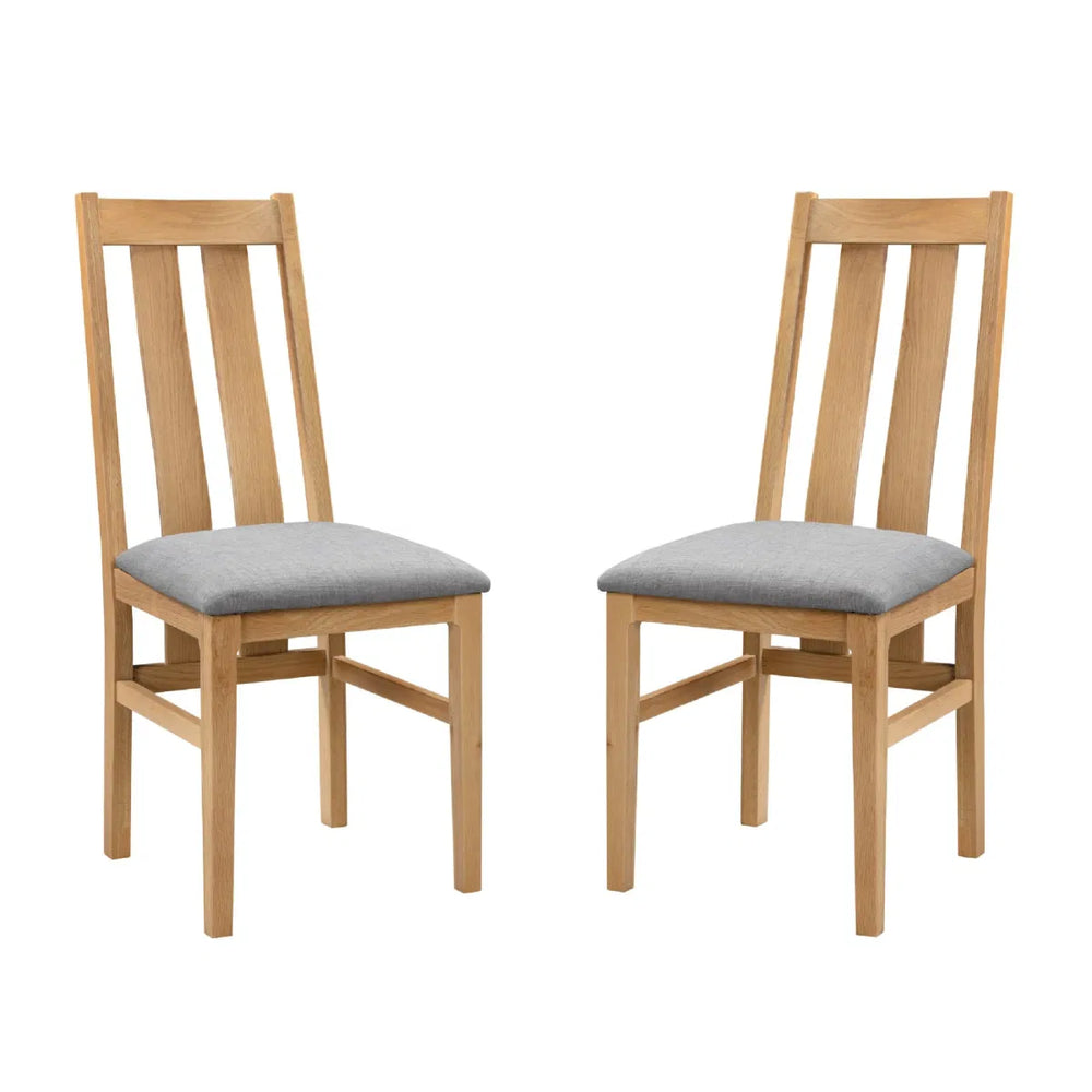 Two wooden chairs with gray cushions on a white background