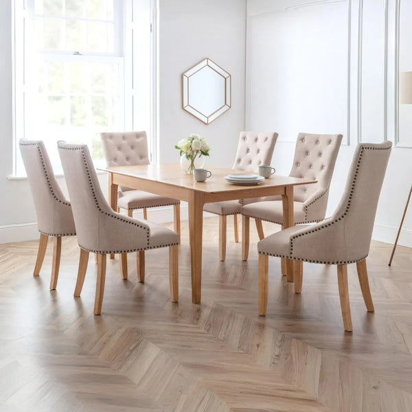 Dining room with wooden table and beige chairs on a wooden floor.