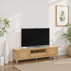 Wooden TV stand with a television in a room with plants and a framed picture on the wall.