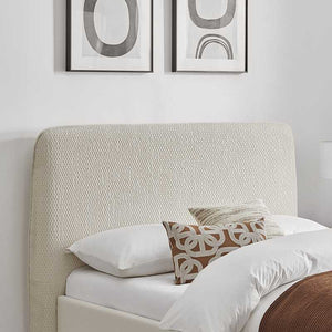 Bedroom with textured headboard and framed abstract art on the wall