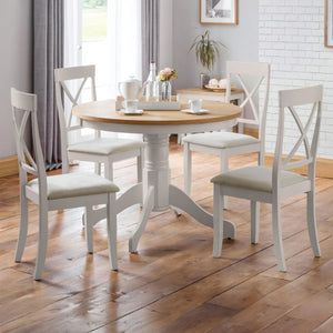 Dining room with a round wooden table and four matching chairs on a wooden floor.