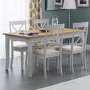 Dining room with a wooden table and white chairs against a green wall.