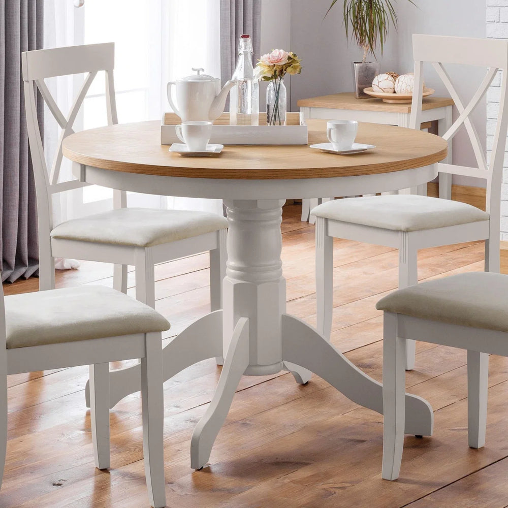 Round dining table with wooden top and white base on a white background