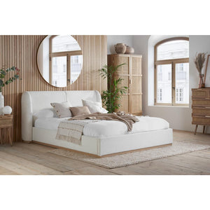 White bed in a bedroom with wooden flooring and furniture.