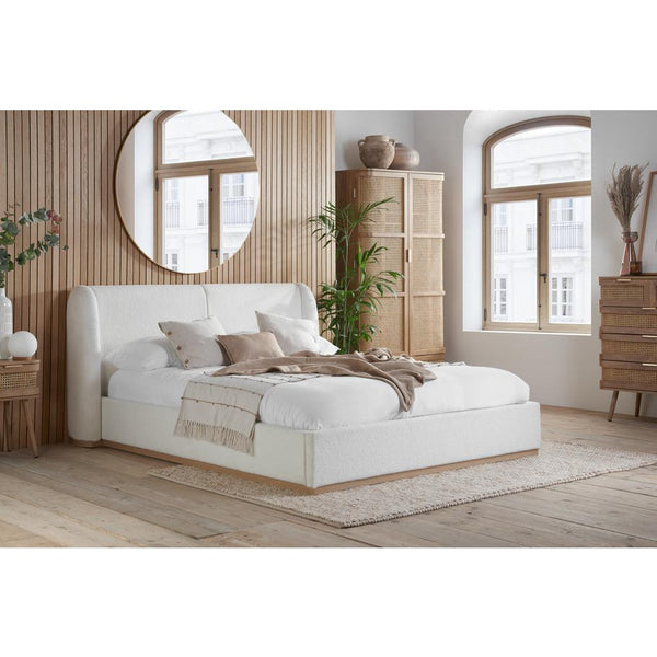 White bed in a bedroom with wooden flooring and furniture.