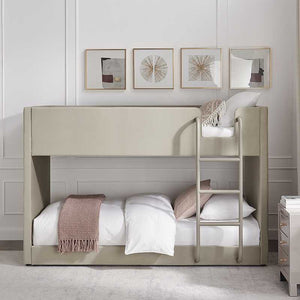 Beige bunk bed in a room with framed artwork on the wall.