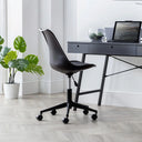 Black office chair in front of a desk with a laptop and plants in a bright room.