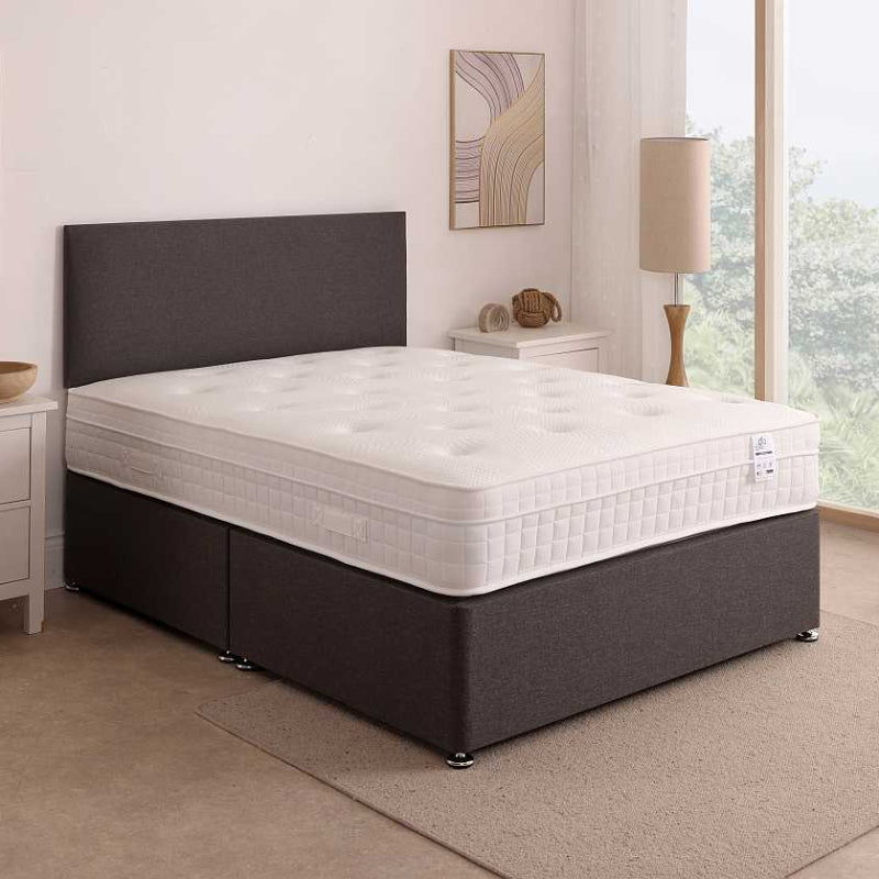 Bed with white mattress and brown frame on a white background
