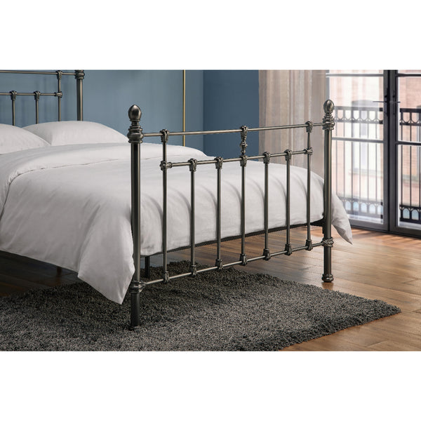 Metal bed frame with white bedding in a room with a balcony.
