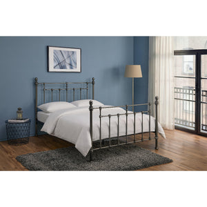 Bedroom with a metal bed frame, white bedding, and decorative items.
