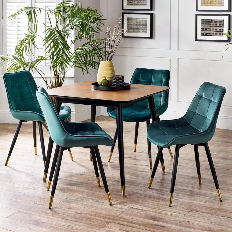 Square table with wooden top and black legs with gold accents on a white background