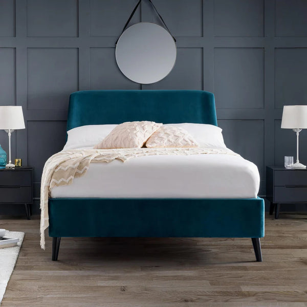 Teal bed frame with white bedding in a bedroom setting.