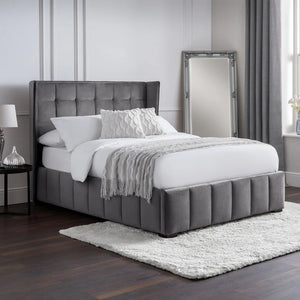 Gray upholstered bed with white bedding in a bedroom setting