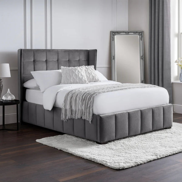 Gray upholstered bed with white bedding in a bedroom setting