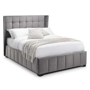 Gray upholstered bed with white bedding on a white background