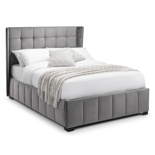Gray upholstered bed with white bedding on a white background