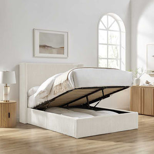 Beige upholstered bed with storage drawers in a bright bedroom setting.