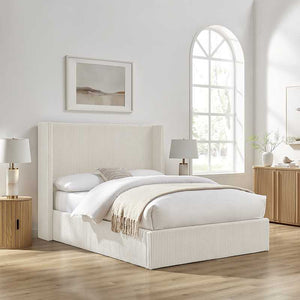 White bed in a bright bedroom with wooden furniture and decor.