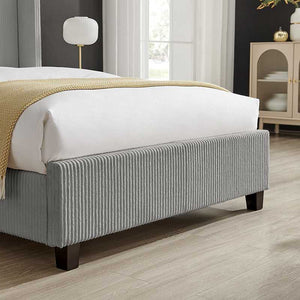 Gray upholstered bed with white bedding in a bedroom setting