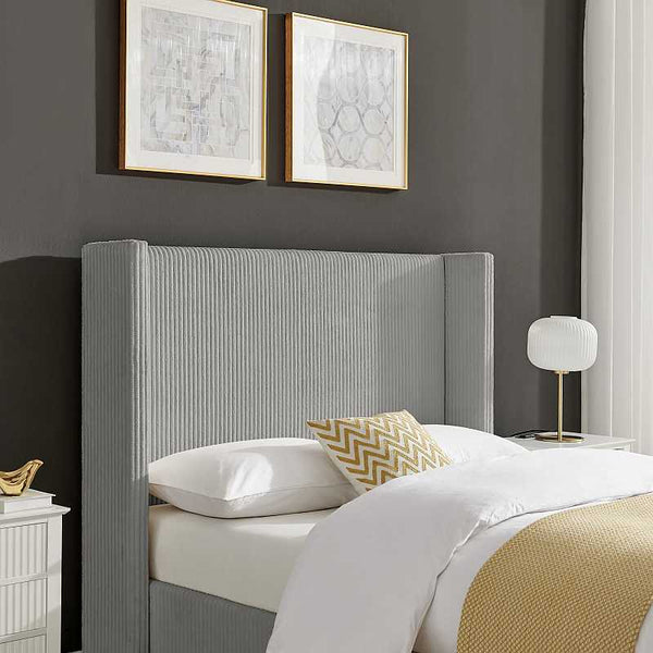 Bedroom with a gray upholstered headboard, white bedding, and decorative pillows.