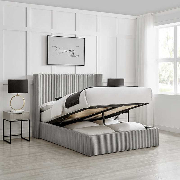 Gray upholstered bed with storage drawers in a modern bedroom setting.
