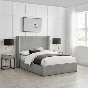 Modern bedroom with a gray upholstered bed, nightstands, and lamps.
