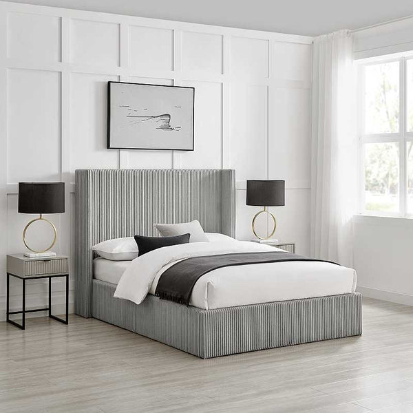 Modern bedroom with a gray upholstered bed, nightstands, and lamps.