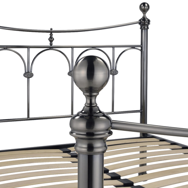 Metal bed frame with decorative headboard and footboard on a white background