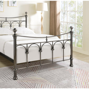 Metal bed frame in a bedroom with a lamp and window in the background